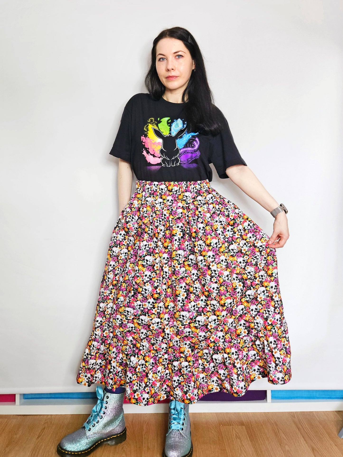 Woman wearing a skirt with colourful skull and floral pattern