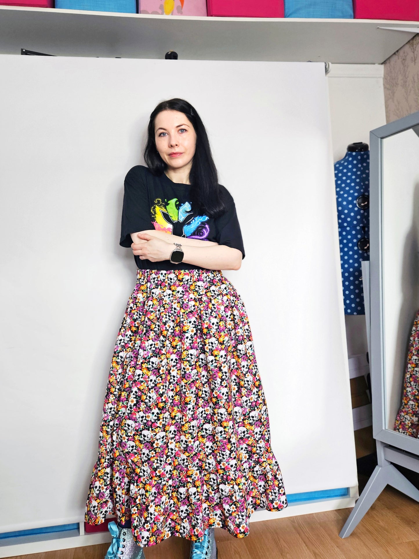 Woman wearing a skirt with colourful skull and floral pattern