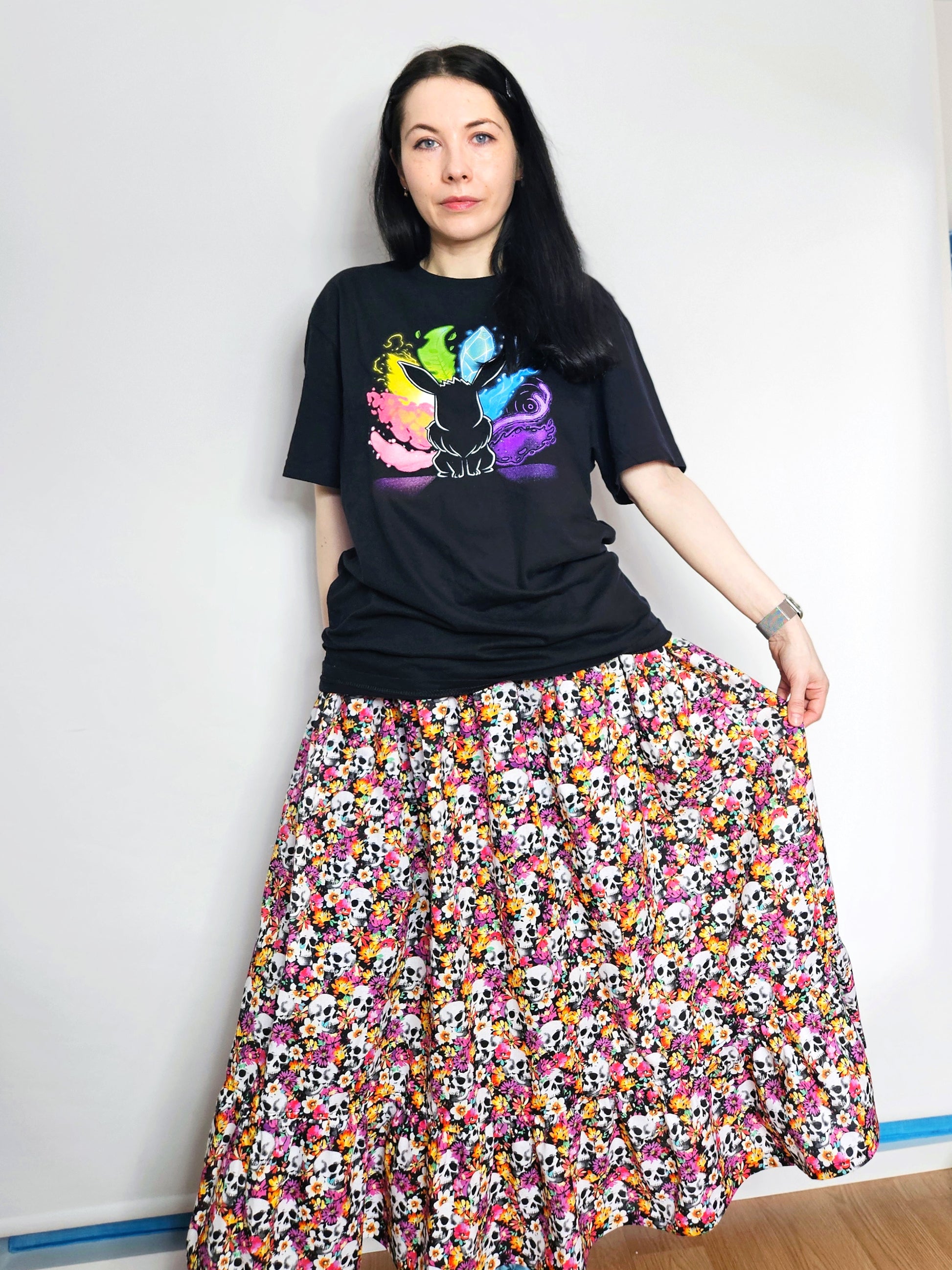 Woman wearing a skirt with colourful skull and floral pattern