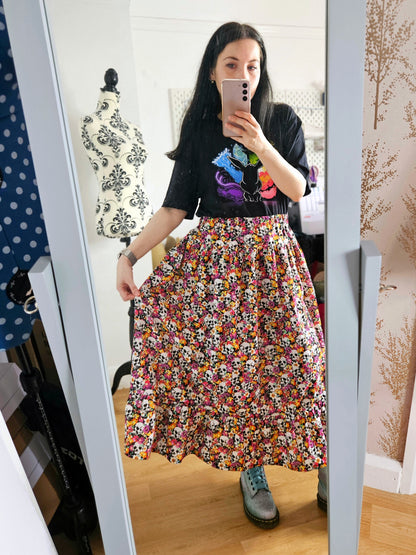 Woman wearing a skirt with colourful skull and floral pattern
