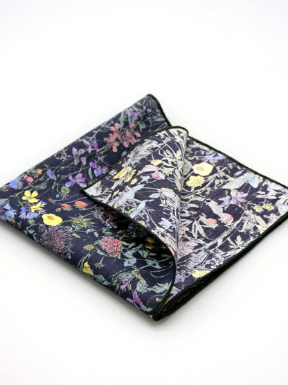 Floral patterned Liberty print pocket square with one corner folded over on a pale grey background