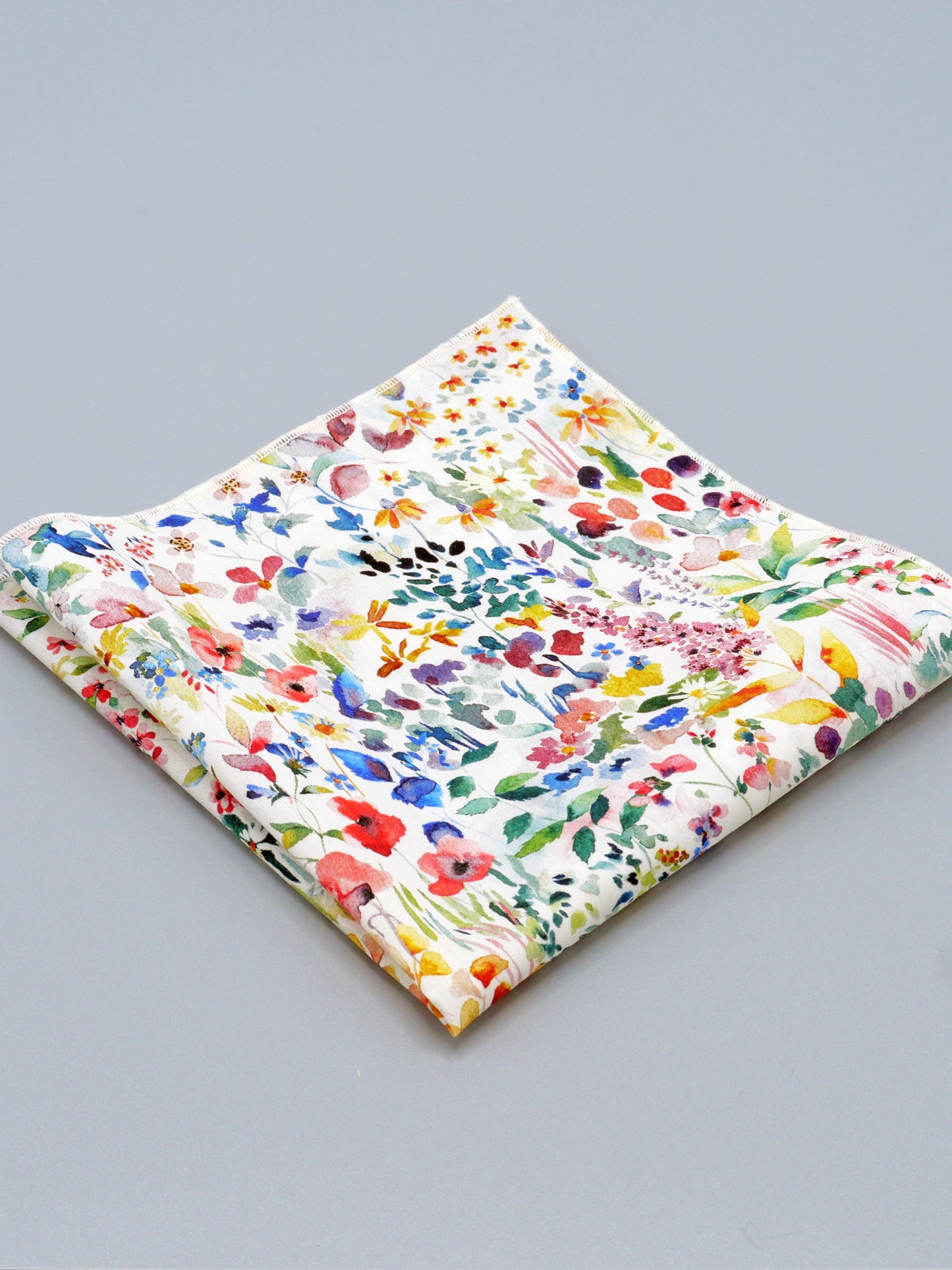 Colourful floral patterned pocket square on a grey background