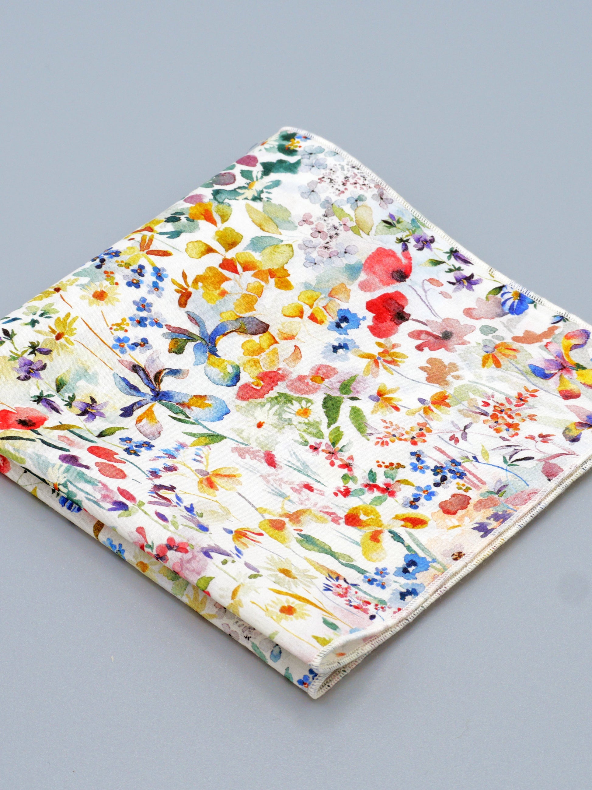 Colourful floral patterned pocket square on a grey background