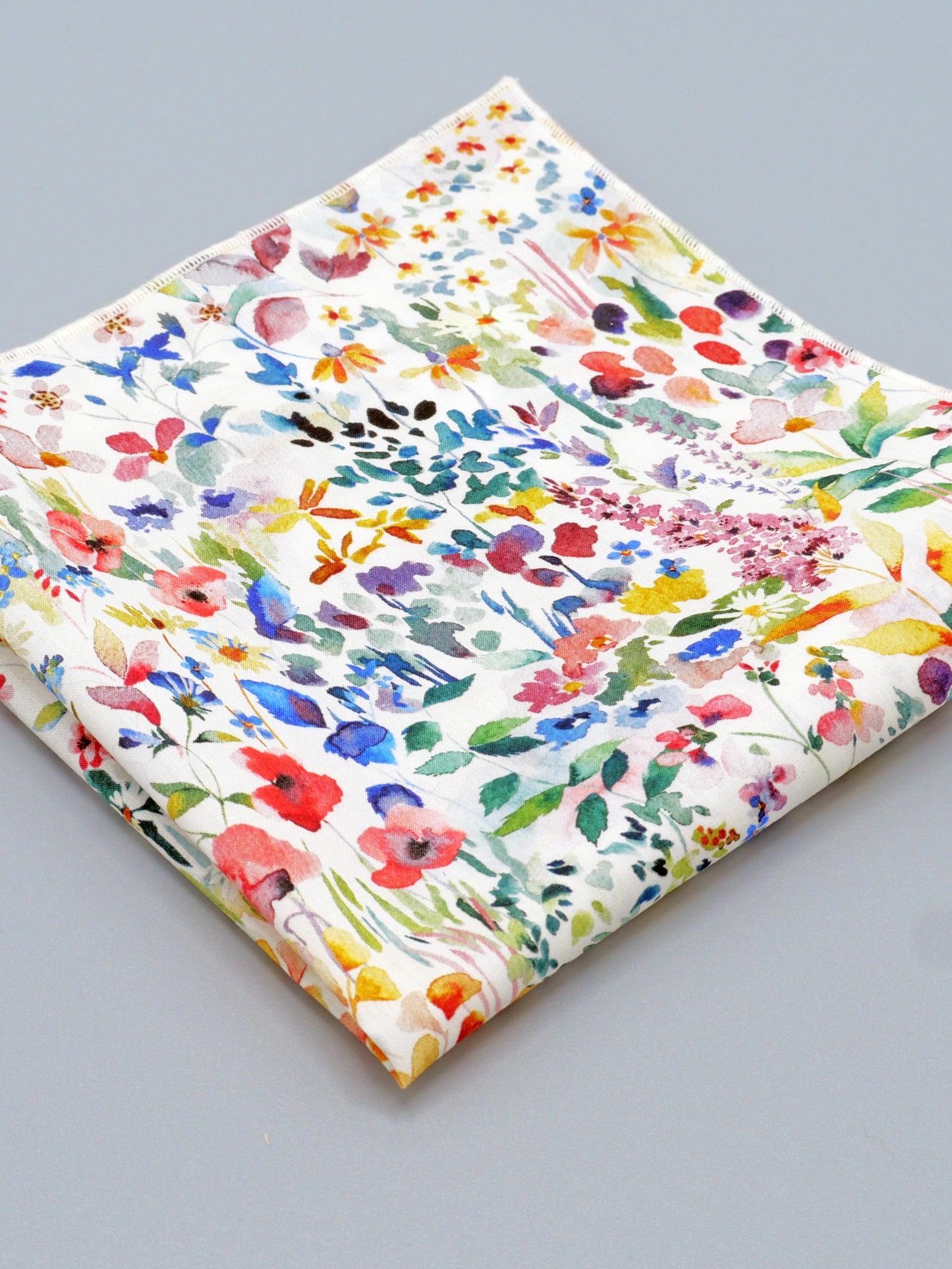 Colourful floral patterned pocket square on a grey background