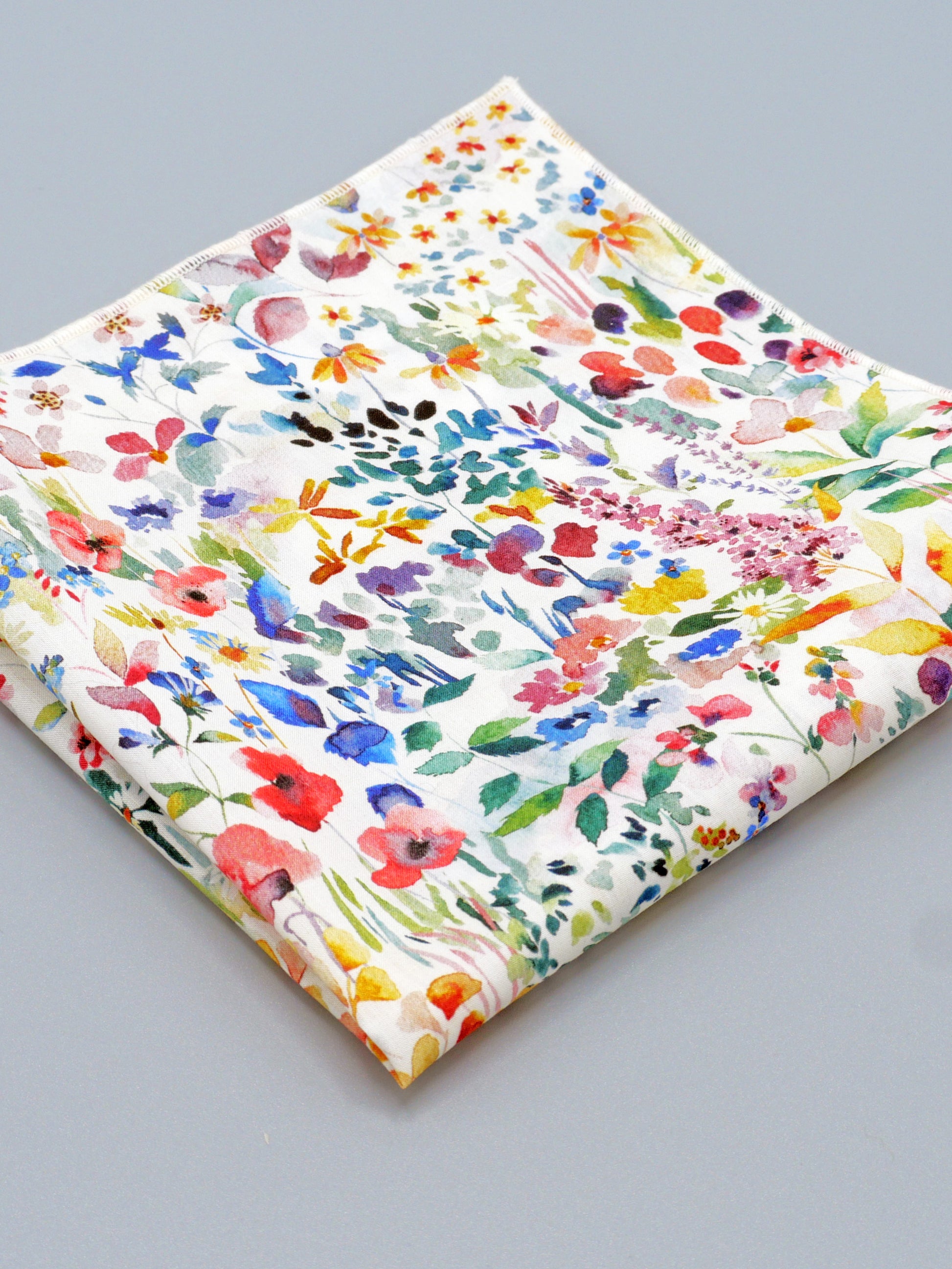 Colourful floral patterned pocket square on a grey background