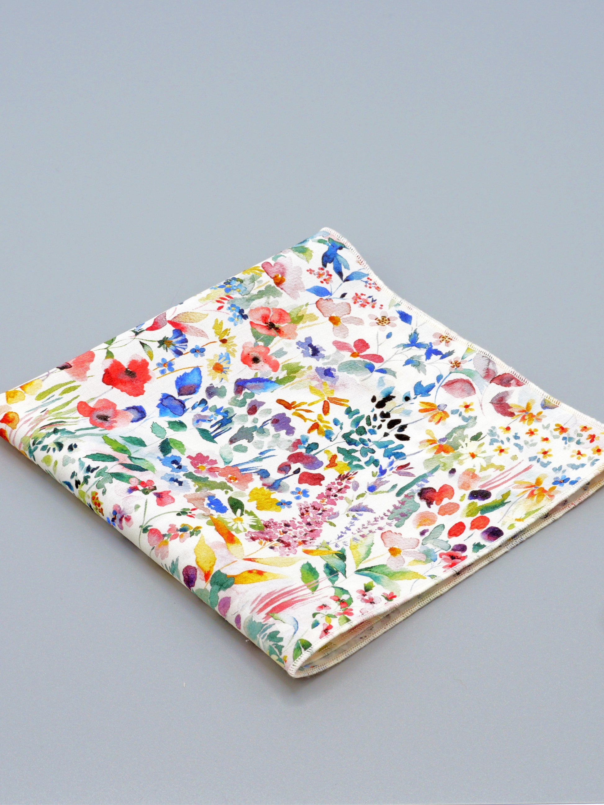 Colourful floral patterned pocket square on a grey background