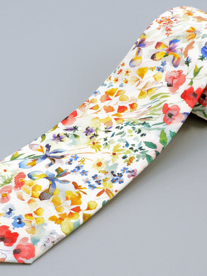 A close-up of a floral watercolour style patterned tie on a grey background