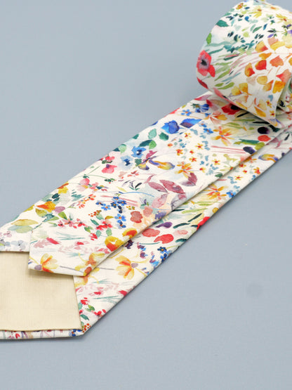 Floral watercolour style patterned tie with a cream-coloured tip lining on a grey background