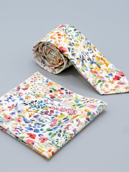 Floral watercolour style patterned tie with a matching pocket square on a grey background