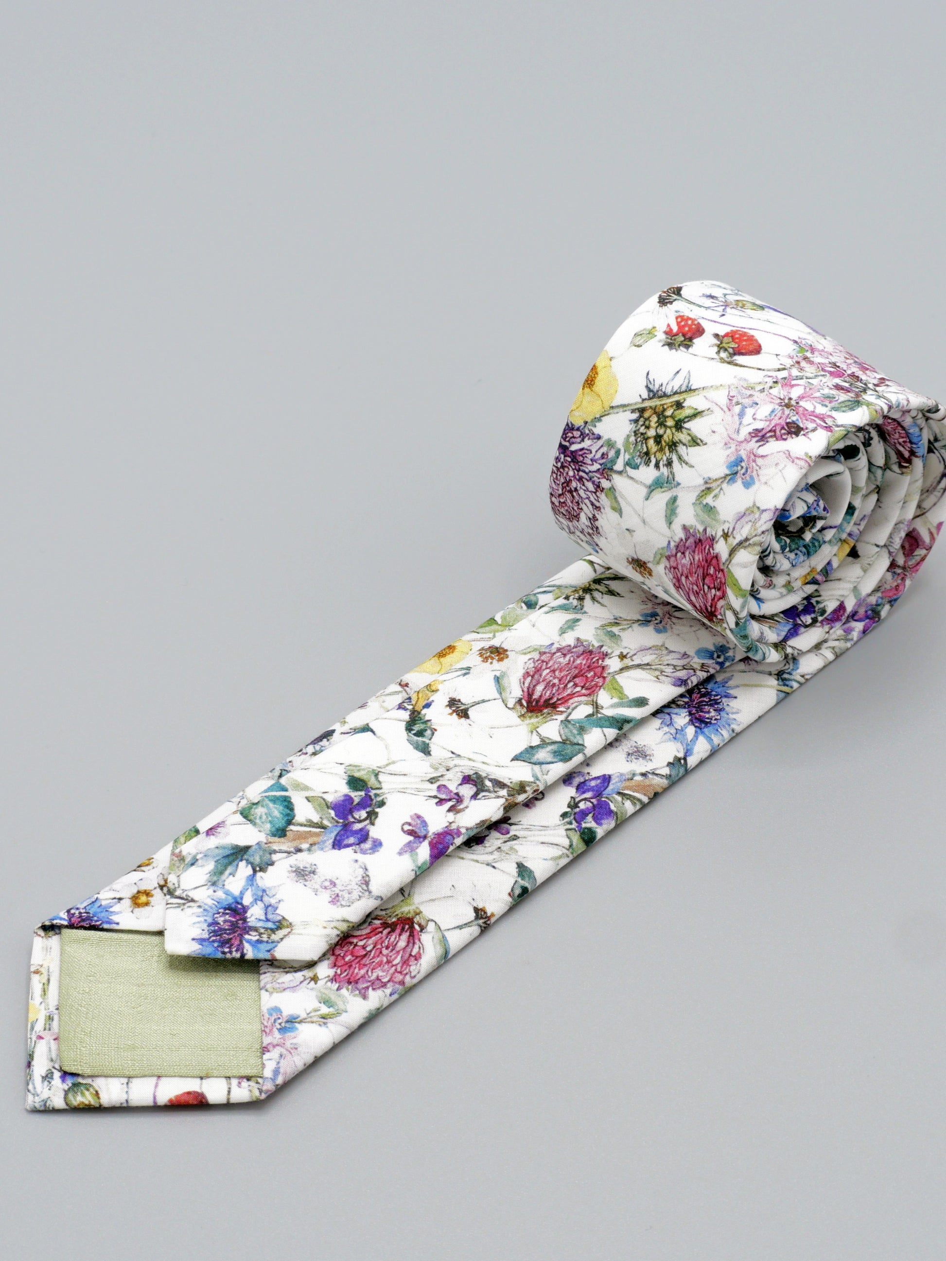 Floral-patterned tie with pale green lined tips on a grey background