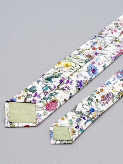 Floral-patterned necktie with pale green lined tips on a grey background