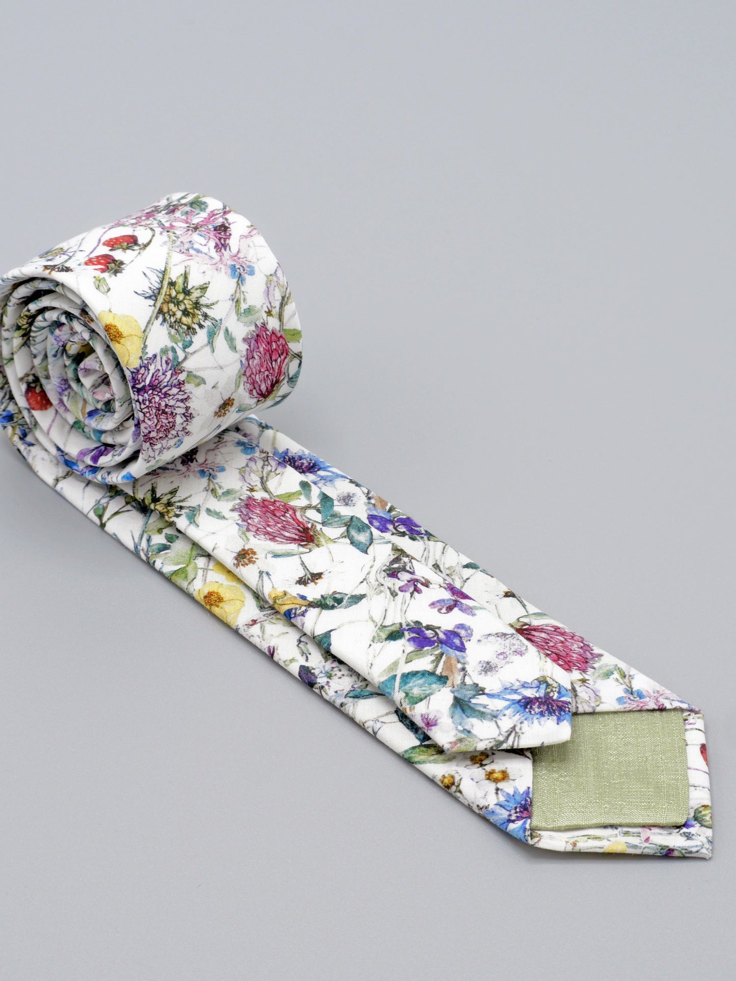 Floral-patterned tie with pale green lined tips on a grey background