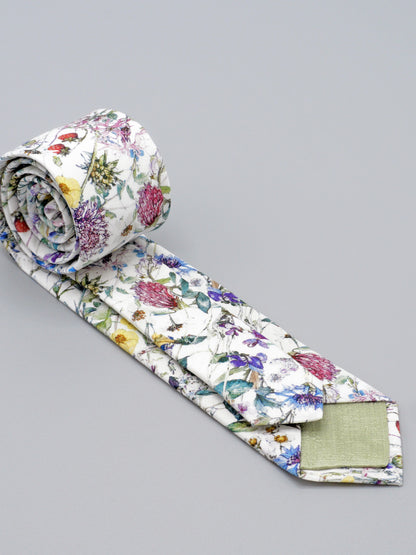 Floral-patterned tie with pale green lined tips on a grey background