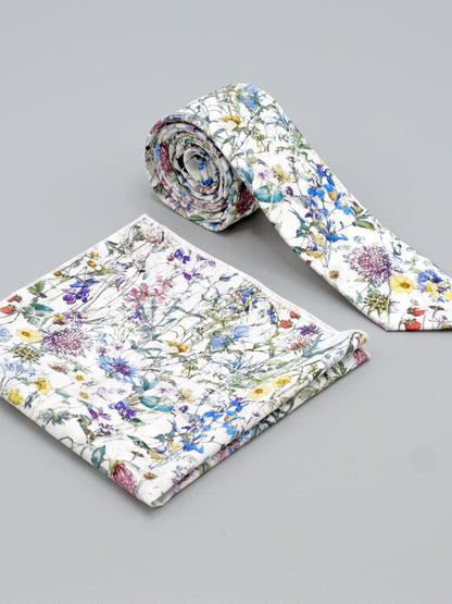 Floral-patterned tie and a matching pocket square on a grey background