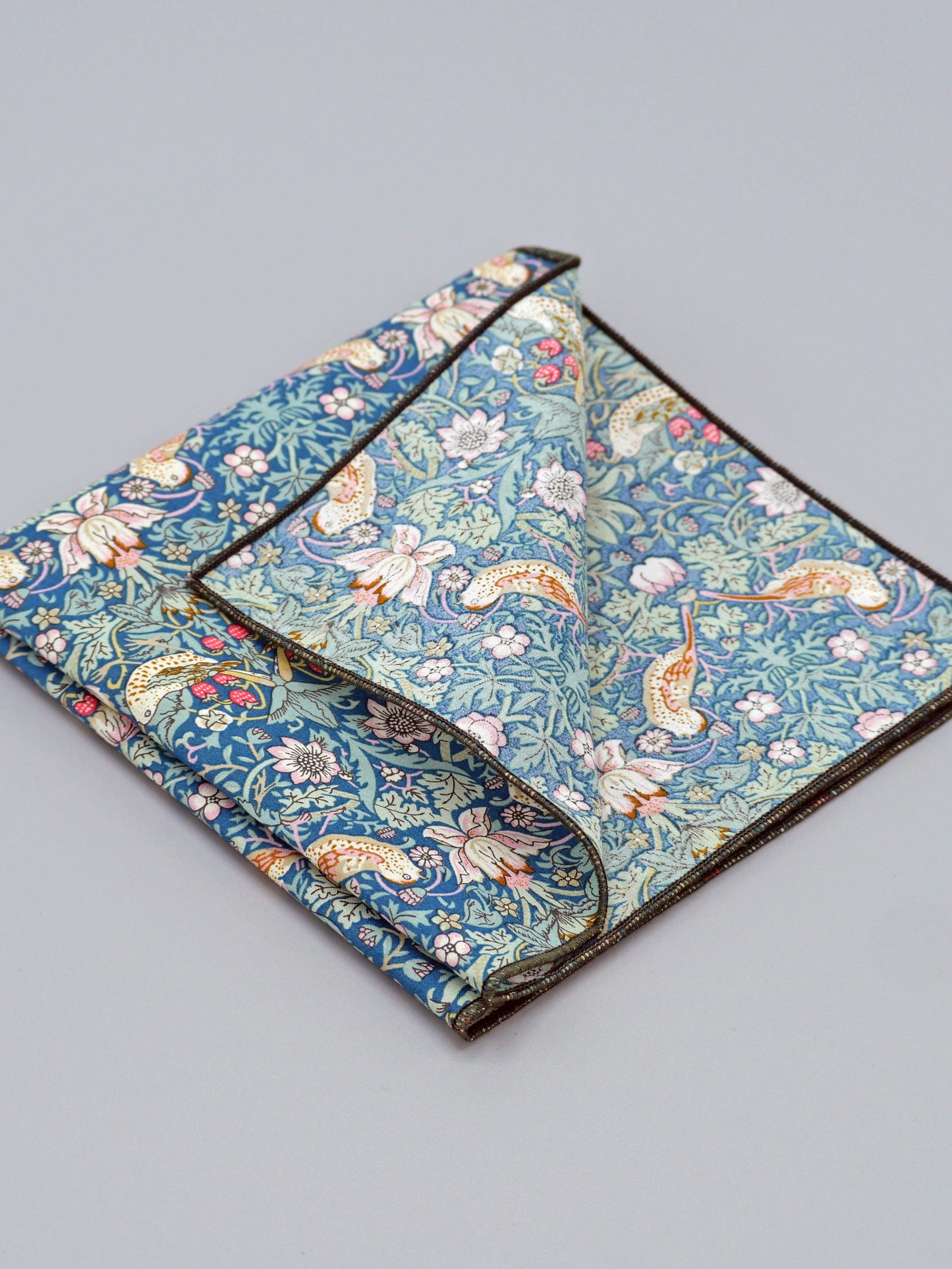 William Morris Strawberry Thief print floral patterned pocket square with a bird and strawberry motif, with one corner folded over