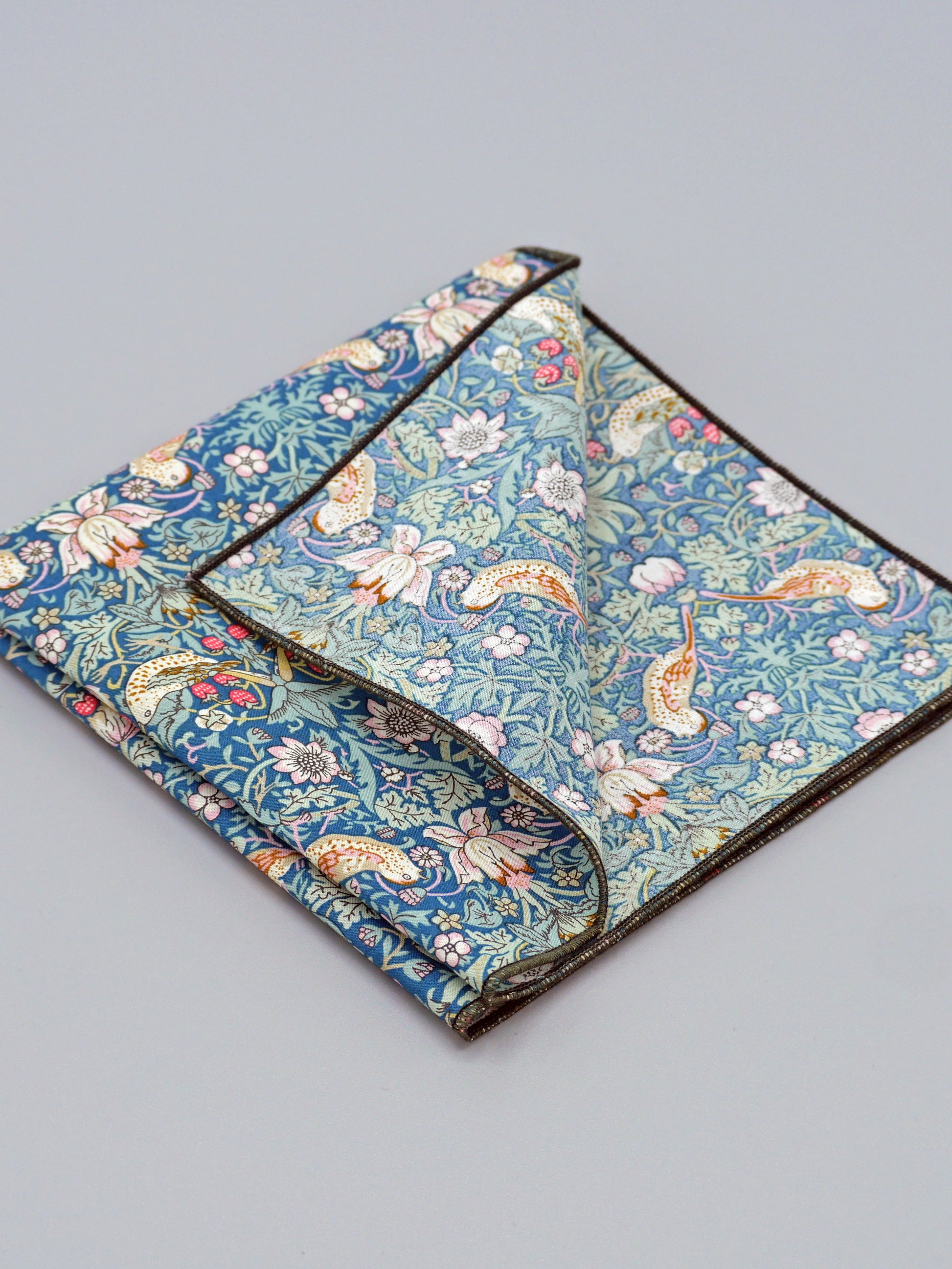 William Morris Strawberry Thief print floral patterned pocket square with a bird and strawberry motif, with one corner folded over
