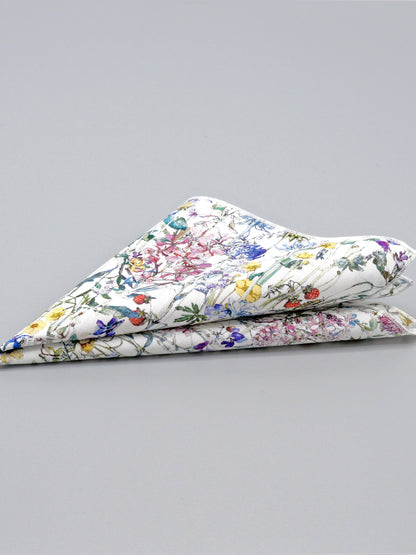 Floral patterned pocket square folded into a triangle on a grey background